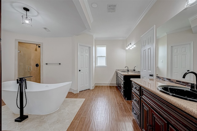 bathroom featuring hardwood / wood-style floors, vanity, ornamental molding, and plus walk in shower