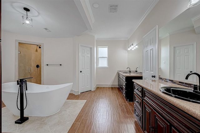1810 Mccrary Rd, Richmond, TX 77406 - full bath with a freestanding bath, two vanities, crown molding, wood finished floors, and a tile shower