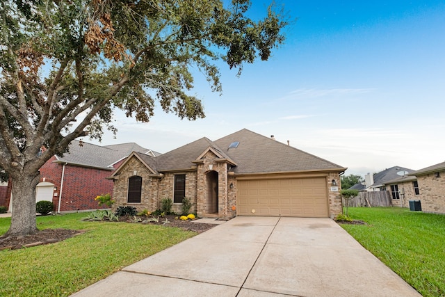 view of front facade featuring a garage, cooling unit, and a front lawn