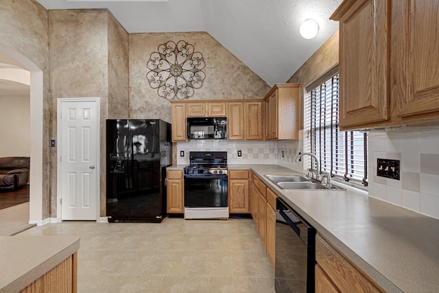 kitchen featuring black appliances, a textured ceiling, sink, light tile patterned floors, and high vaulted ceiling