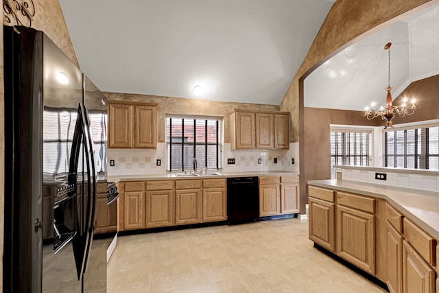 kitchen with hanging light fixtures, a wealth of natural light, black appliances, and a notable chandelier