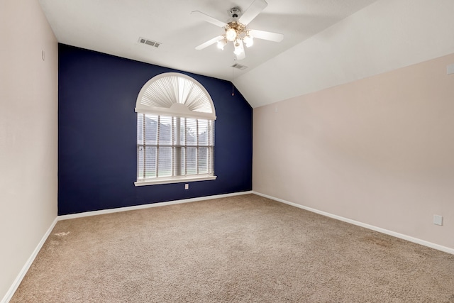 carpeted empty room featuring ceiling fan and vaulted ceiling