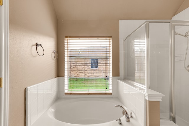 bathroom featuring shower with separate bathtub, a healthy amount of sunlight, and vaulted ceiling