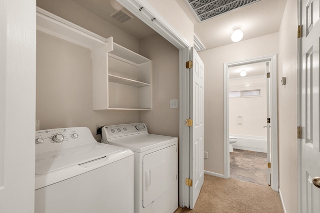 clothes washing area with light carpet and washing machine and clothes dryer