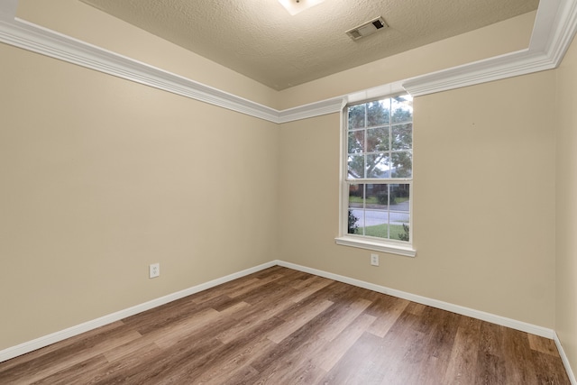 unfurnished room with wood-type flooring, a textured ceiling, and ornamental molding