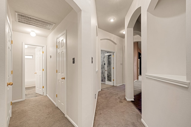 hallway with light colored carpet