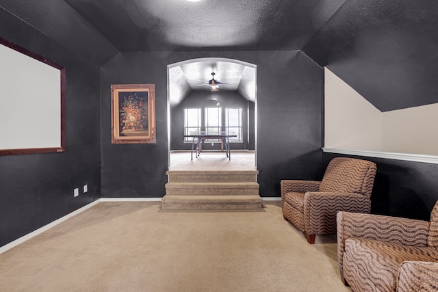 sitting room with carpet, a textured ceiling, lofted ceiling, and ceiling fan