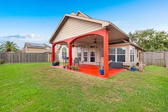 rear view of property with a lawn, ceiling fan, and a patio