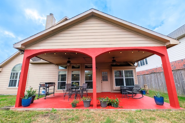 rear view of property with a lawn, ceiling fan, and a patio