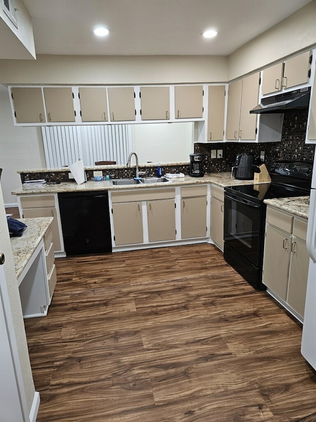 kitchen with sink, black appliances, light stone countertops, dark wood-type flooring, and decorative backsplash