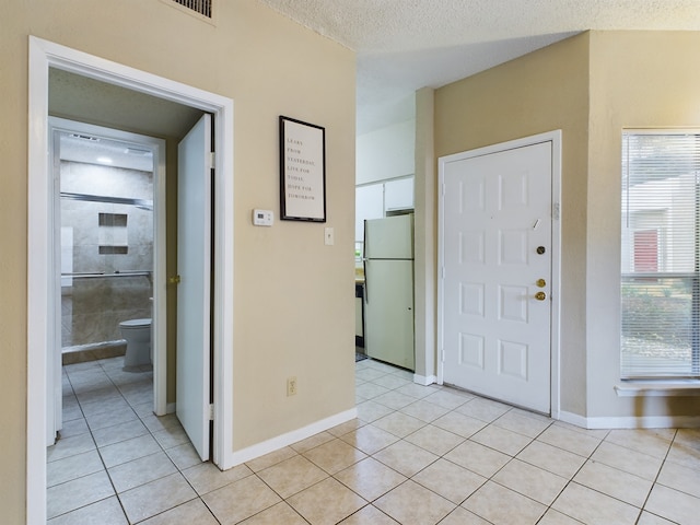 tiled foyer with a textured ceiling