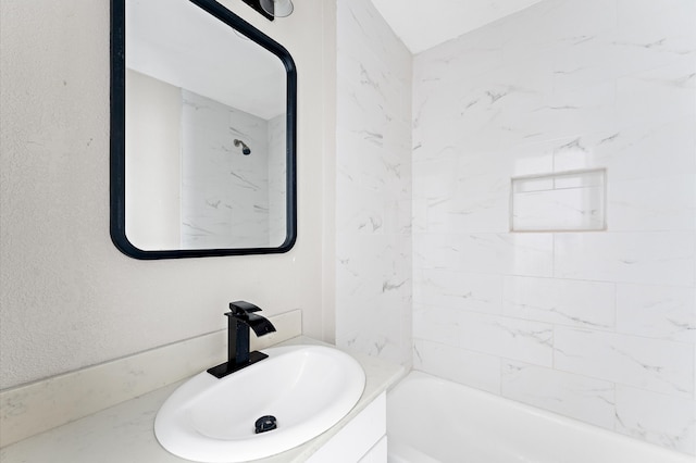 bathroom featuring vanity and tiled shower / bath