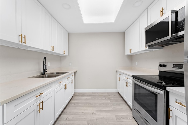 kitchen featuring white cabinetry, light wood-type flooring, sink, and stainless steel appliances