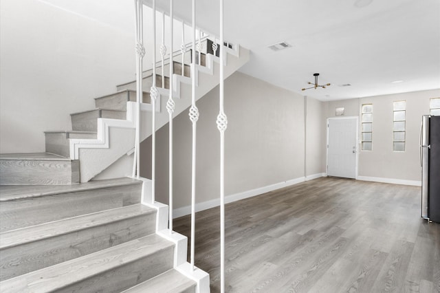 213 Super St, Houston, TX 77011 - staircase featuring wood finished floors, baseboards, and a chandelier