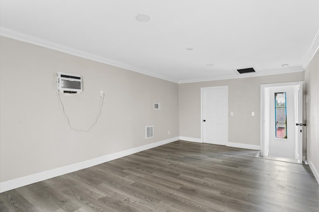 spare room featuring dark hardwood / wood-style floors, a wall mounted air conditioner, and ornamental molding