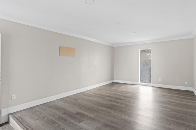 spare room featuring dark wood-type flooring and ornamental molding