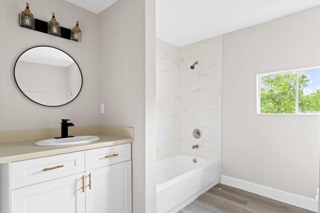 bathroom with hardwood / wood-style floors, vanity, and tiled shower / bath combo