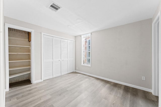 unfurnished bedroom featuring a closet and light hardwood / wood-style flooring