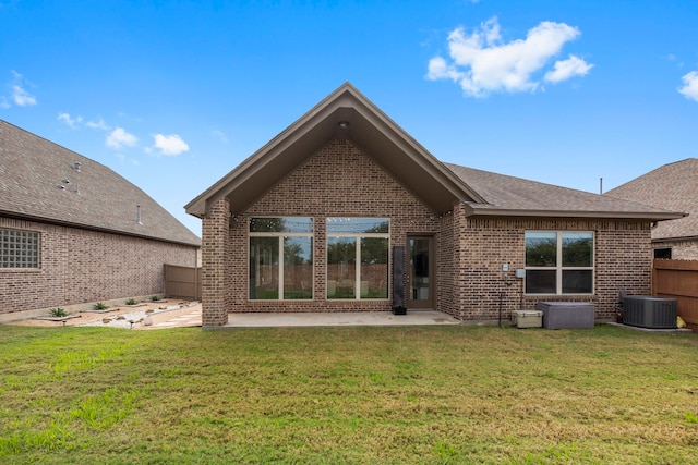 rear view of property with a lawn, cooling unit, and a patio