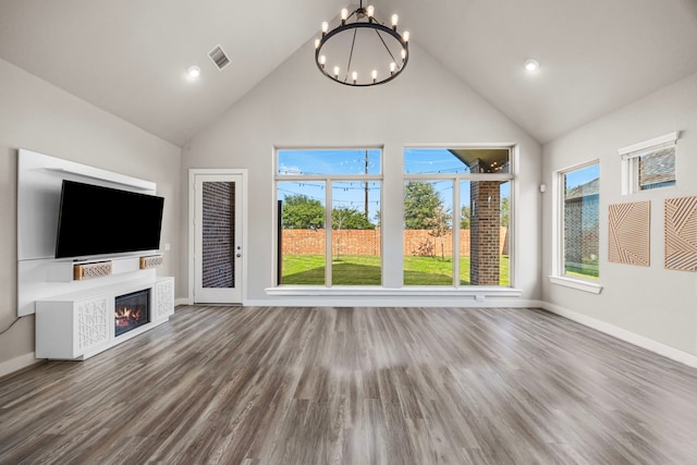 2215 Rose Manor Ct, Richmond, TX 77469 - unfurnished living room with high vaulted ceiling, a chandelier, baseboards, a glass covered fireplace, and wood finished floors