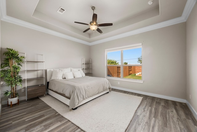 bedroom featuring a tray ceiling, ceiling fan, and wood-type flooring