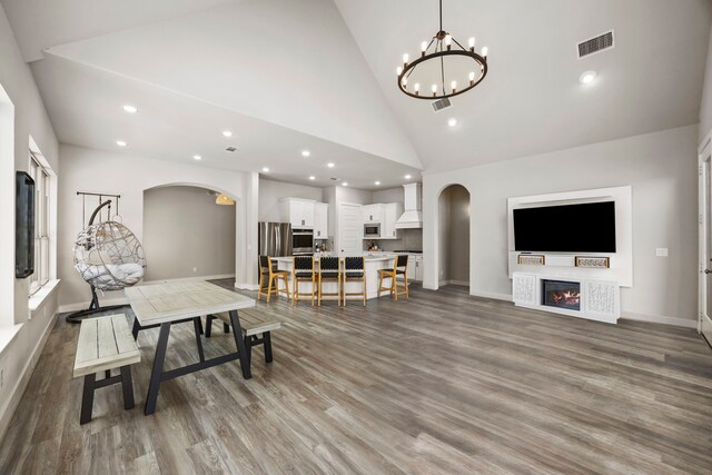 2215 Rose Manor Ct, Richmond, TX 77469 - living area with arched walkways, wood finished floors, recessed lighting, a chandelier, and high vaulted ceiling