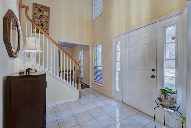 tiled entryway featuring a towering ceiling