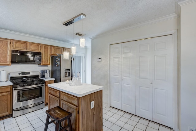 kitchen with a textured ceiling, hanging light fixtures, light tile patterned floors, a kitchen island, and stainless steel appliances