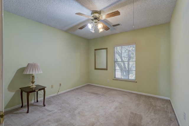 carpeted empty room featuring a textured ceiling and ceiling fan