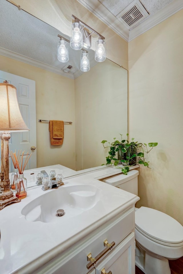 bathroom with toilet, vanity, and ornamental molding