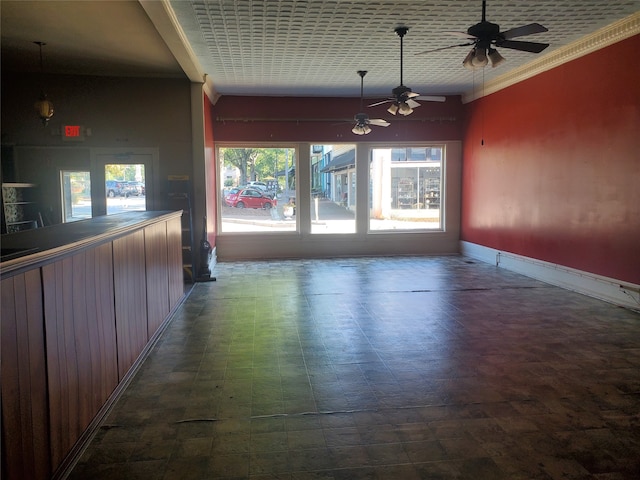 empty room featuring ceiling fan and crown molding