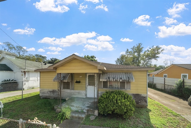 bungalow-style house featuring a front lawn