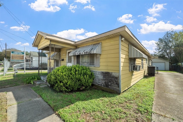 view of property exterior with central air condition unit, cooling unit, and a lawn