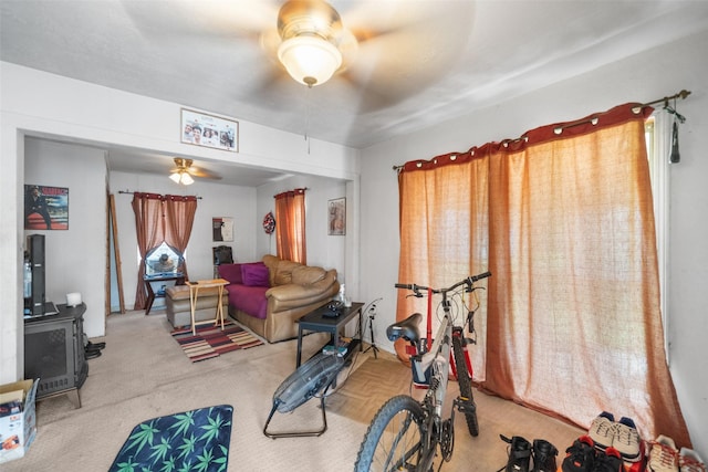 workout area with a wood stove and ceiling fan