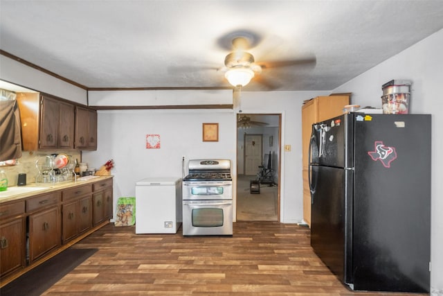 kitchen with stainless steel gas range oven, black fridge, fridge, and light wood-type flooring