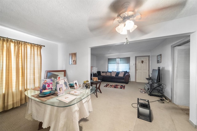 dining area with light carpet, a textured ceiling, and ceiling fan