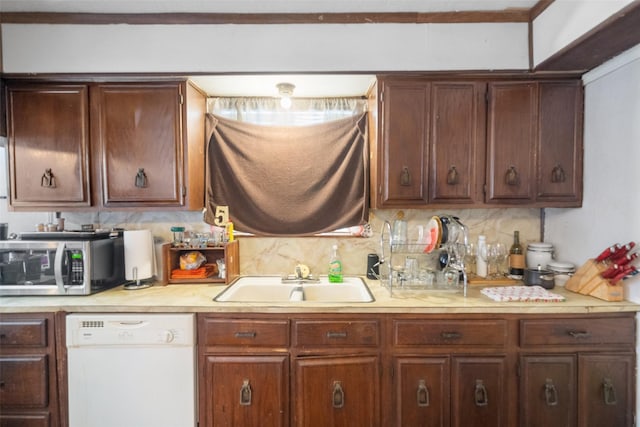 kitchen with white dishwasher, sink, and tasteful backsplash