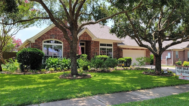 view of front of house featuring a garage and a front lawn