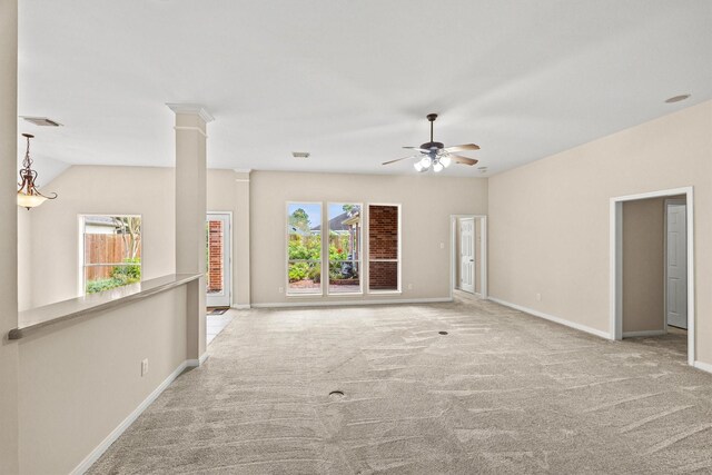 carpeted spare room with vaulted ceiling, ornate columns, and ceiling fan