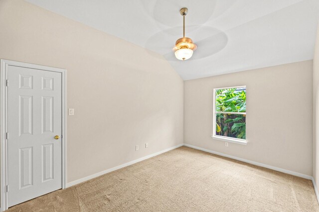 carpeted empty room with ceiling fan and vaulted ceiling