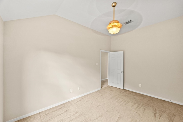 carpeted empty room featuring vaulted ceiling