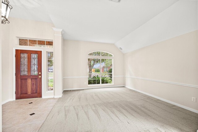 carpeted foyer with lofted ceiling