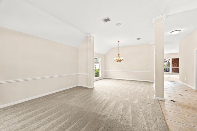 carpeted empty room featuring ornate columns, lofted ceiling, and a notable chandelier