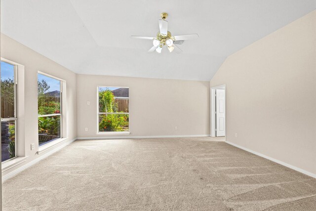 spare room featuring ceiling fan, light colored carpet, and lofted ceiling