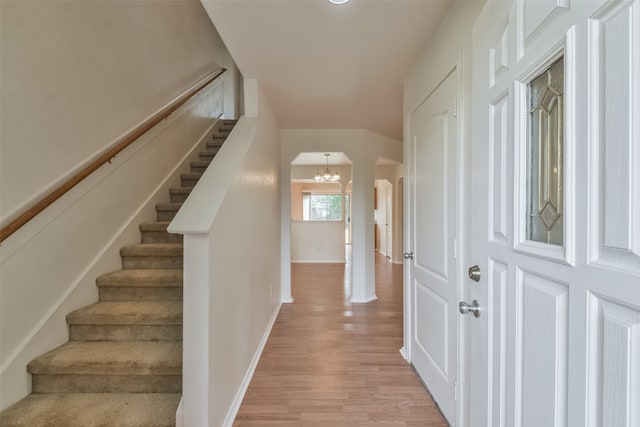 foyer entrance with a chandelier and light hardwood / wood-style flooring