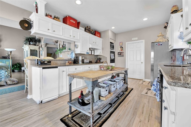 kitchen featuring white cabinets, sink, and light wood-type flooring