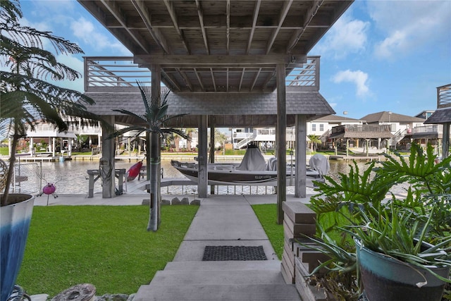 exterior space featuring a dock, a yard, and a water view