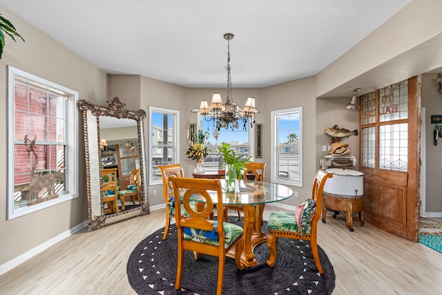 dining space featuring an inviting chandelier, plenty of natural light, and light hardwood / wood-style flooring