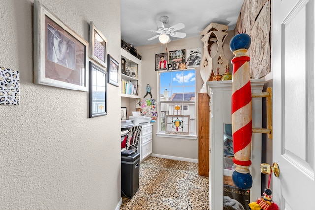 interior space with ceiling fan and a textured ceiling