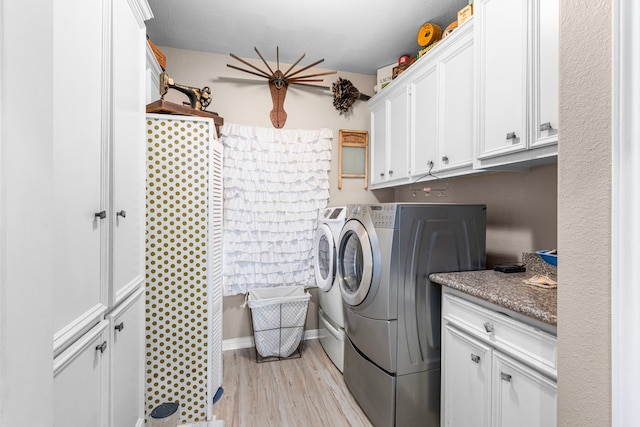 clothes washing area with light hardwood / wood-style flooring, cabinets, and washer and dryer